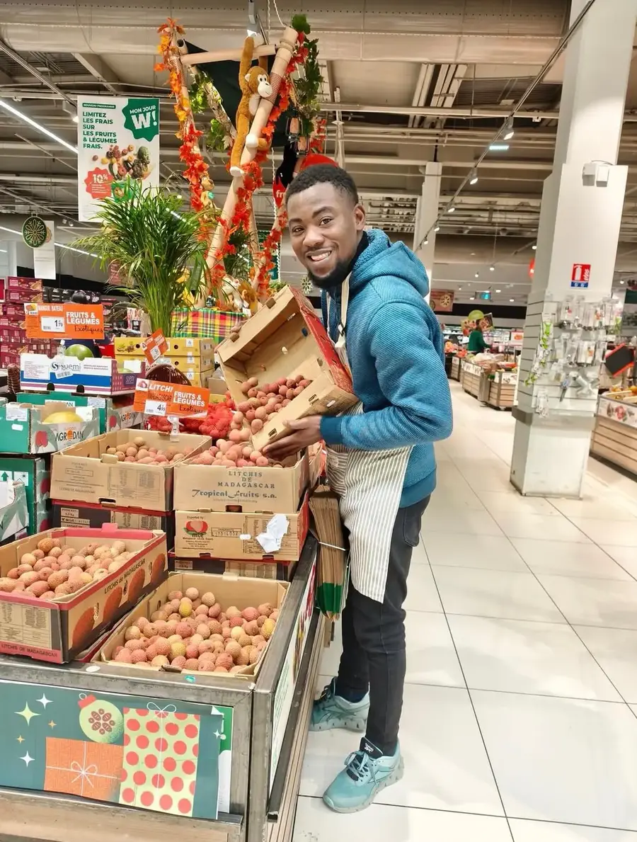 Animateur ATRESSS mettant en rayon des litchis en point de vente